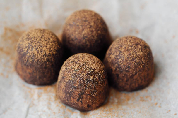 Delicious chocolates truffles with cocoa on paper  - Photo, Image