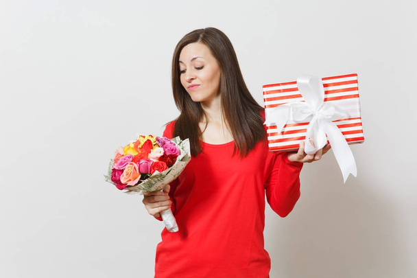Sad upset woman in red clothes holding bouquet of beautiful roses flowers, present box with gift isolated on white background. St. Valentine's Day, International Women's Day birthday holiday concept. - Photo, Image