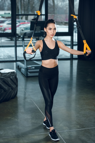 young sporty woman working out with resistance bands at gym - Photo, Image