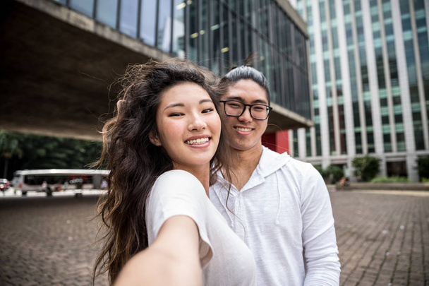 Asiática pareja tomando un selfie
 - Foto, imagen