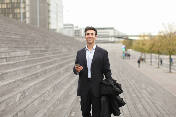 European businessman walking and speaking by telephone. - Fotografie, Obrázek