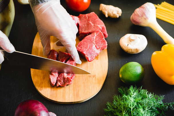 Cook leikkaamalla raakaa lihaa
  - Valokuva, kuva