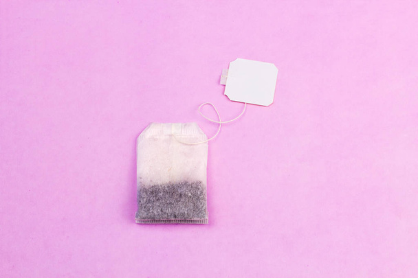 Tea bag on pastel pink background in minimalism style. - Photo, image