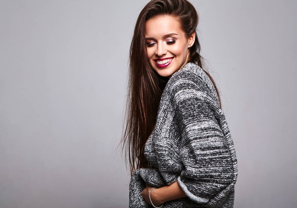 Portrait of beautiful cute brunette woman model in casual warm sweater clothes isolated on gray with evening makeup and colorful lips - Zdjęcie, obraz