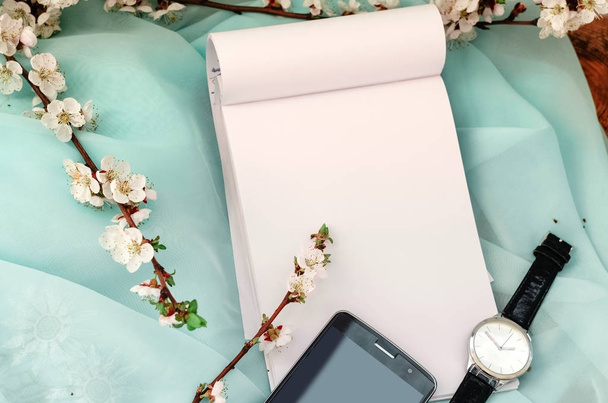креативный рабочий стол Чистый лист в блокноте. наручные часы и телефон
 - Фото, изображение