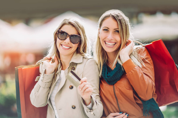 Amigos felices de compras. Dos hermosas mujeres jóvenes disfrutando de compras
 - Foto, imagen