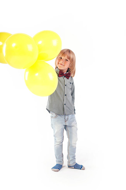 Stylish little boy dressed in red bow tie holding air balloon isolated on white background. Smile. - Fotografie, Obrázek