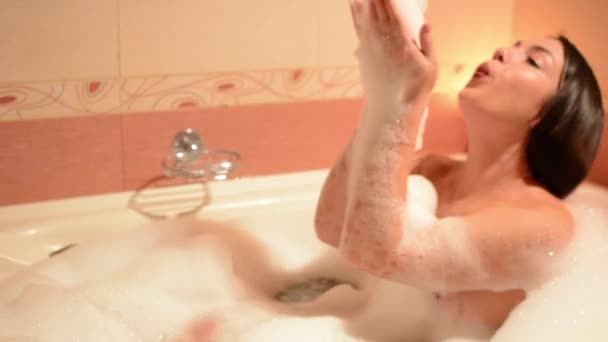 Fiatal nő fürdő pihentető fürdőzés. Nő élvezi a fürdő hab a kád. - Felvétel, videó