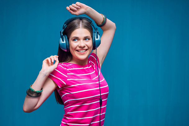 Smiling happy woman in casual clothes listening to music on big headphones  - Foto, imagen