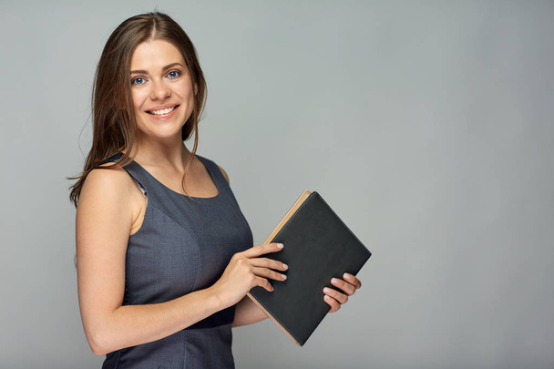 beautiful teacher woman holding book and posing on grey background  - Fotó, kép