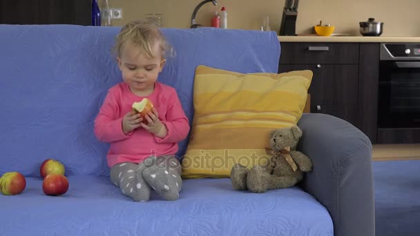 girl eat red fresh apple sit sofa. healthy lifestyle, food. 4K - Filmati, video