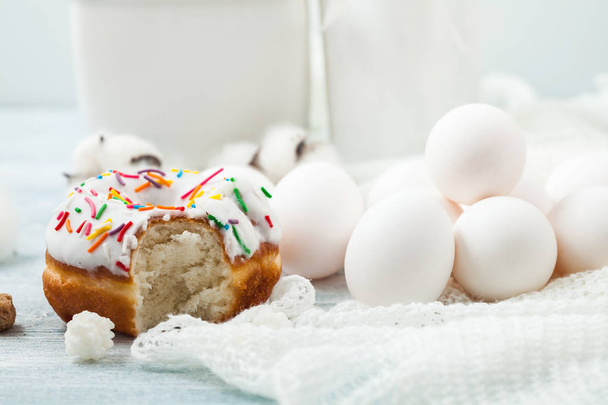 Donuts with icing on a white table, white eggs, Easter concept Menu, restaurant recipe concept Served in. - Фото, зображення