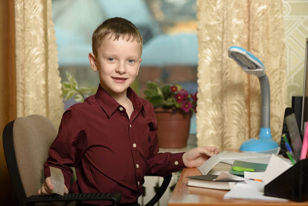 Мальчик работает в своем офисе на персональном компьютере. Держит палку.
 - Фото, изображение