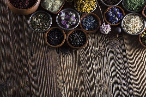 Alternative medicine. Herbs in bowls, mortar and medicine bottles on wooden rustic table. - Foto, Imagem