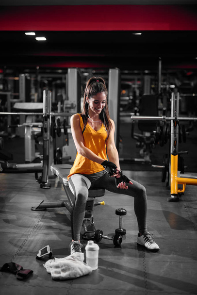 beautiful smiling young woman exercising with dumbbells in gym - Photo, Image