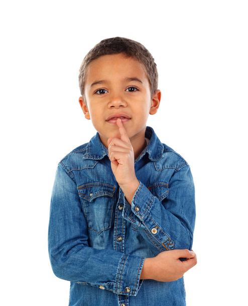 cute little African boy in denim shirt with forefinger at his lips as sign of silence, isolated on white background - Photo, Image