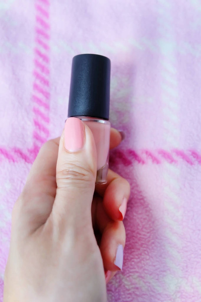 Pink Painted Nails. Beautiful Pink Nail Manicure with Pink Bottle in Woman is Hand on Pink Background Great for Any Use. - Fotoğraf, Görsel