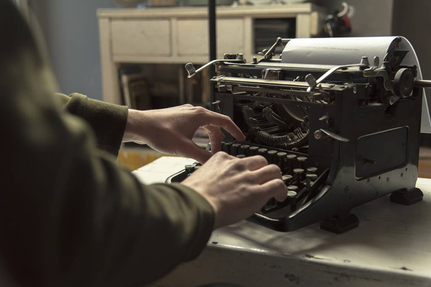 Ο άνθρωπος χρησιμοποιώντας πληκτρολόγησης ρετρό γραφομηχανή συγγραφέας μηχάνημα - Φωτογραφία, εικόνα