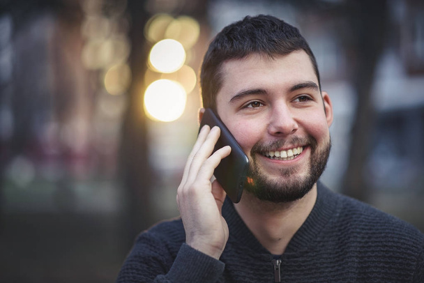 Handsome young man talking on his phone in an urban area - Φωτογραφία, εικόνα