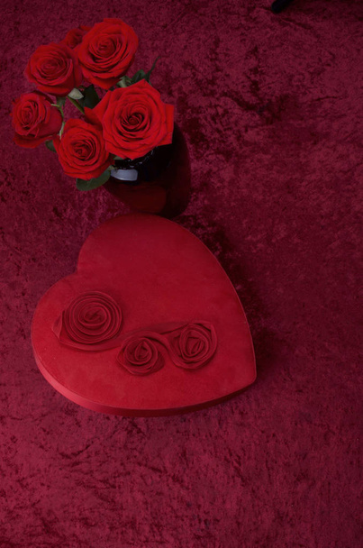 Scena di San Valentino con scatola di cioccolato a forma di cuore, mazzo di rose su sfondo di velluto rosso schiacciato e pizzo bianco corridore
 - Foto, immagini