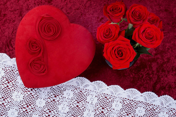 Valentines Scene With Heart Shaped Chocolate Box, Bunch of Roses on Red Crushed Velvet Background and White Lace Runner - Photo, Image