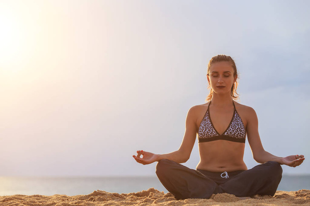 Mujer jugando Yoga y ejercicio en la playa tropical al atardecer
  - Foto, imagen