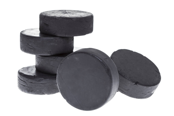 Una pila de discos de hockey bien utilizados sobre un fondo blanco
. - Foto, imagen