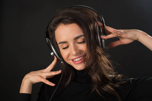 Retrato de una hermosa joven morena escuchando música en auriculares
 - Foto, Imagen