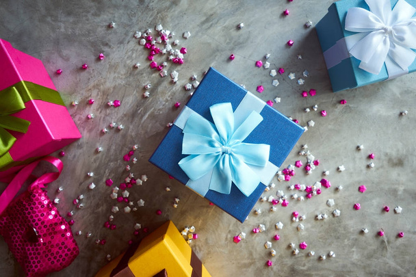 Top view of colorful gift boxes with little pink stars on grey background - Photo, Image