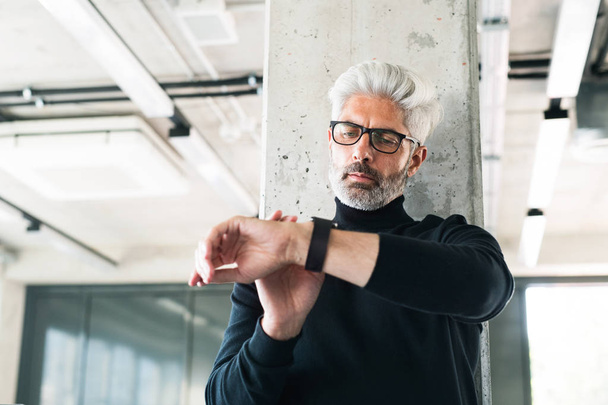 Mature businessman with gray hair in the office. - 写真・画像