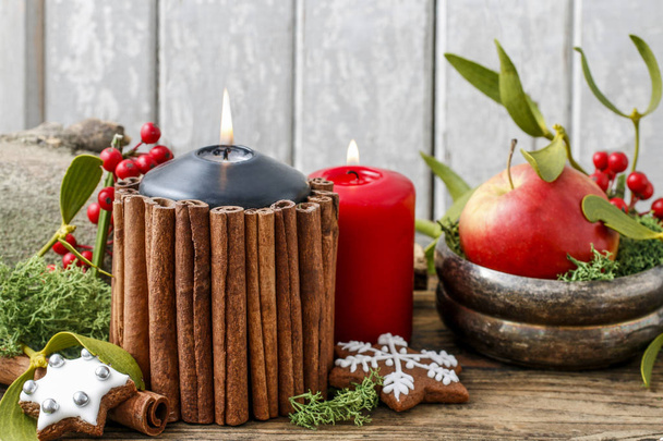 Christmas candle decorated with cinnamon sticks. festive decor - Foto, afbeelding