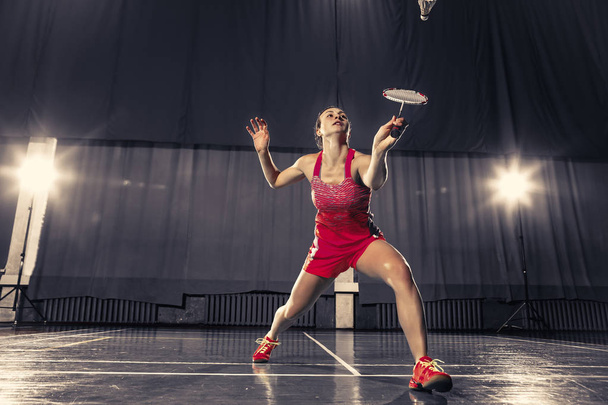 Young woman playing badminton at gym - Foto, Bild