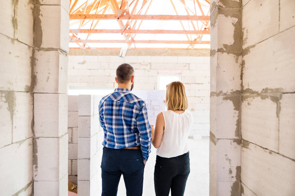 Young couple at the construction site. - Foto, afbeelding