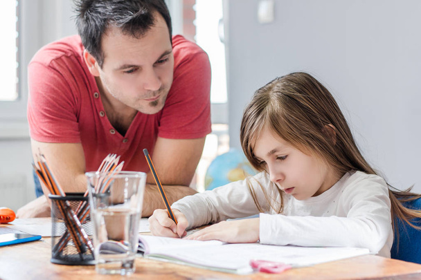 close-up of Father Helping Daughter With Homework at home  - Valokuva, kuva