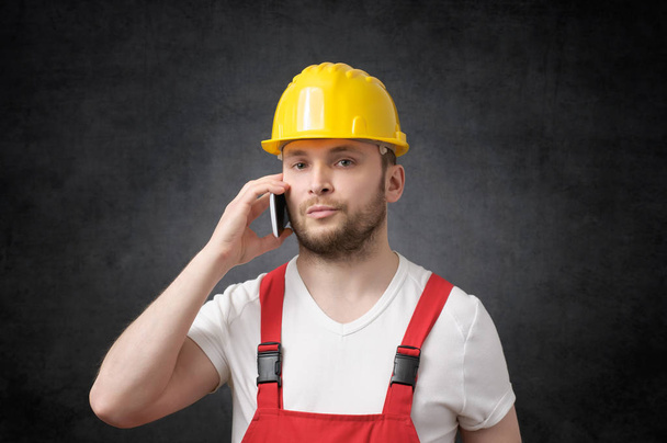Construction worker using smartphone - Foto, afbeelding