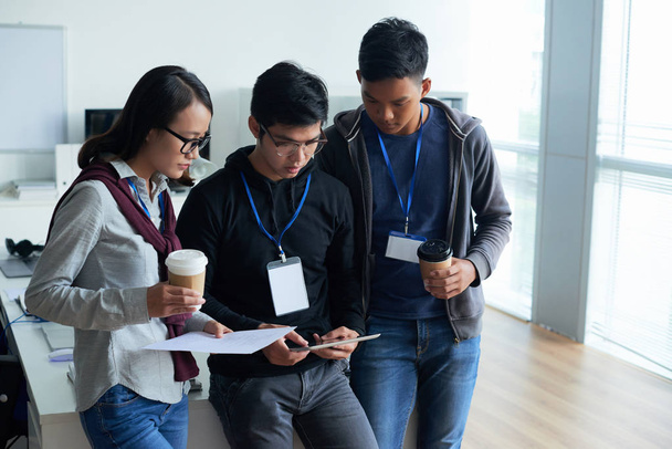 Grupo de desarrolladores asiáticos hablando en la oficina
 - Foto, Imagen