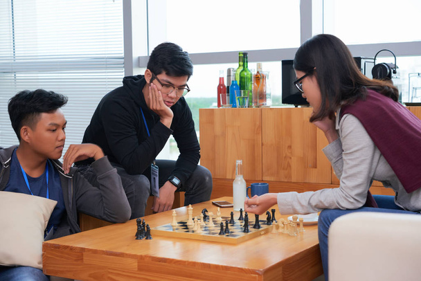 Group of asian friends playing chess at table in office - Foto, Imagen