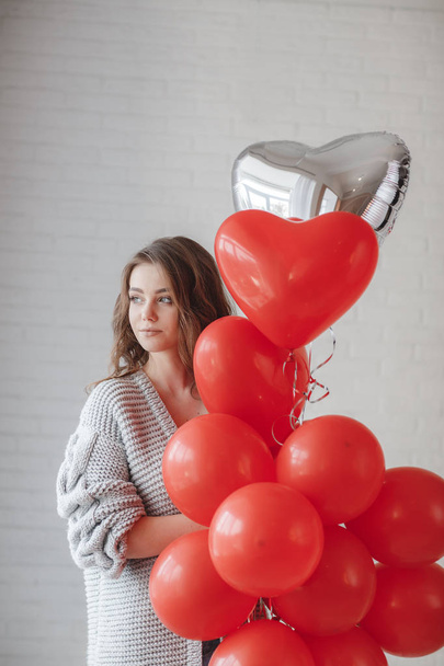 Valentine Beauty girl with colorful air balloons laughing, isolated on background. Beautiful Happy Young woman. holiday party. Joyful model having fun, playing and celebrating with red color balloon - Fotoğraf, Görsel