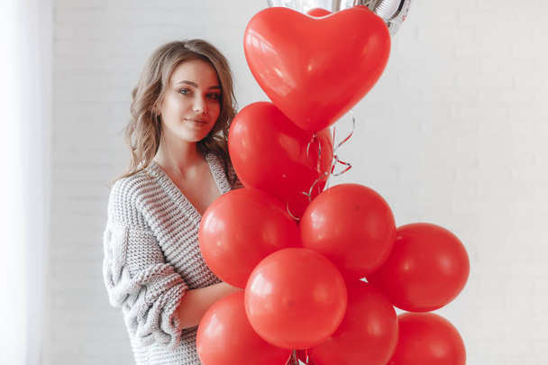 Valentine Beauty girl with colorful air balloons laughing, isolated on background. Beautiful Happy Young woman. holiday party. Joyful model having fun, playing and celebrating with red color balloon - Zdjęcie, obraz