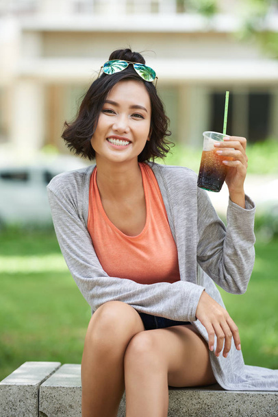 Χαρούμενα βιετναμέζικα γυναίκα δείχνει ποτήρι φραπέ - Φωτογραφία, εικόνα