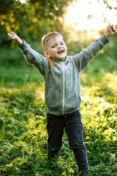 Portrait of blonde little boy posing outside at spring time - Photo, Image