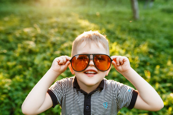attractive little Boy in sunglasses at summer time  - Fotó, kép