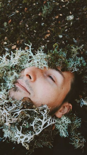 Portrait of young brunette man with closed eyes in green fir-tree branches  - Foto, Imagem