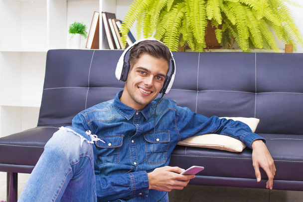 young teenager with mobile phone and headphones at home - Fotó, kép