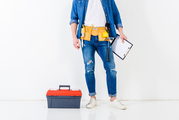cropped image of worker standing with clipboard near tools box - Fotografie, Obrázek