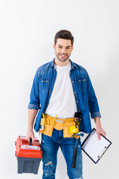 smiling handsome worker with tools box and clipboard - Фото, зображення