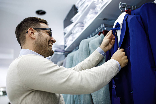 Smiling Young Man Buying a Shirt - 写真・画像