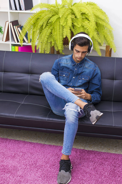 молодий чоловік слухає музику вдома Лаунж з навушниками
 - Фото, зображення