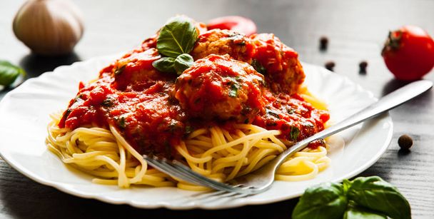 pasta spaghetti with meatballs in tomato sauce on a plate on dark wooden background - Foto, Bild