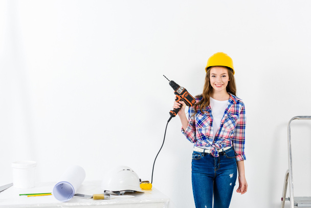 young woman holding drill and looking at camera - Foto, immagini